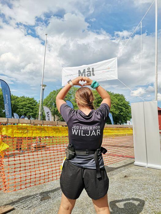 Kvinne med t-skjorte med teksten "jeg løper for Wiljar"