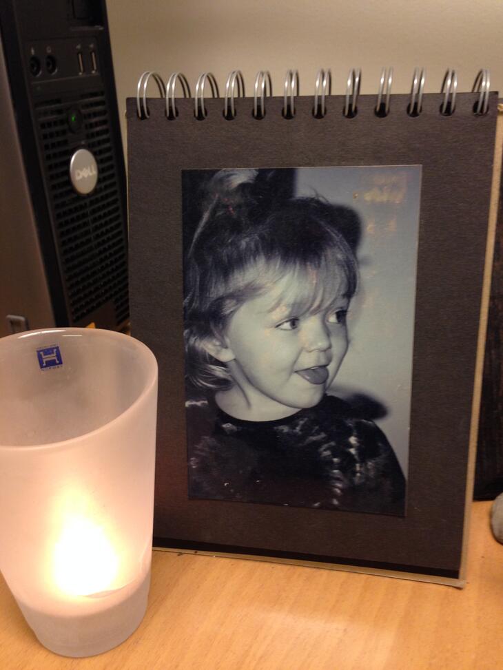 Bilde av Amalie i ramme med tent lys foran.