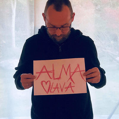 Allan holder opp en plakat der det står "Alma Olava"