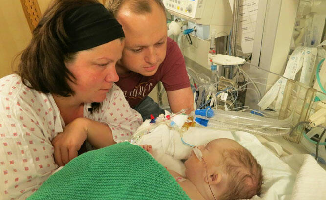 Kristin og Øystein sitter ved siden av lille William som ligger i sykehusseng.